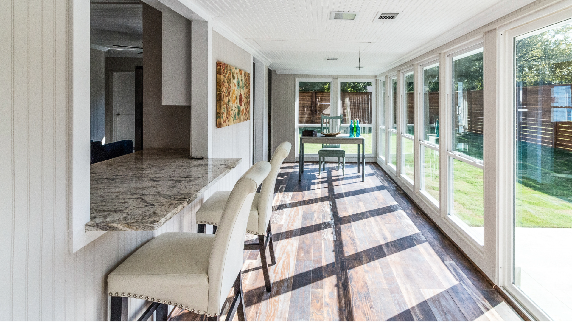 Sunroom addition design with a wall of large windows